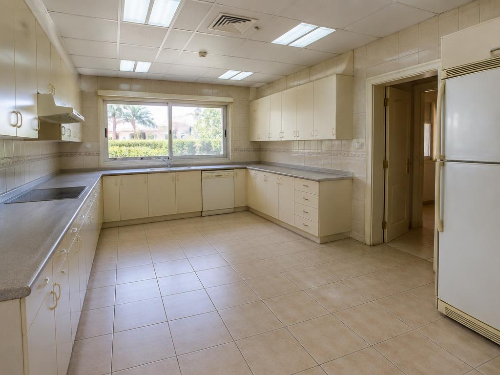 Dated enclosed cream kitchen before renovation at an Emirates Hills villa in Dubai