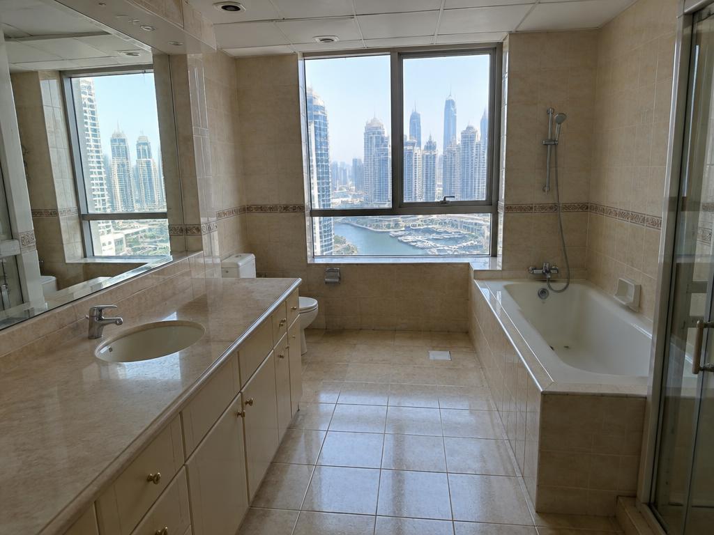 Dated beige-tiled penthouse bathroom before renovation in Dubai Marina